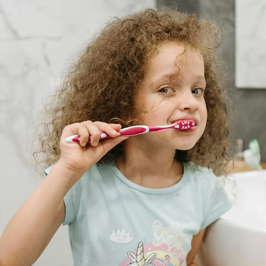 Controllo dei denti a un bambino con lo specchietto odontoiatrico